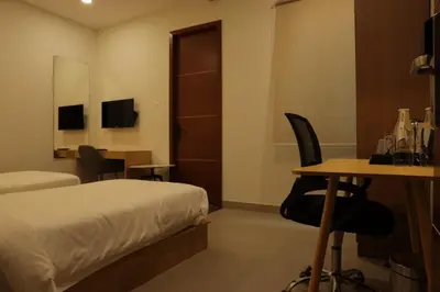 a hotel room with a bed and a desk and a table at Dreamotel Luxury Suites in Kanjikode
