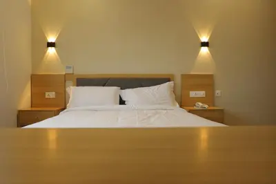 a bedroom with a bed with two lights above it at Dreamotel Luxury Suites in Kanjikode