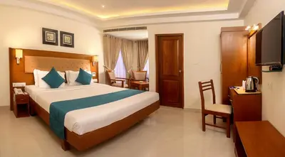 a bedroom with a bed and a desk and a television at Vishnu Inn in Guruvāyūr