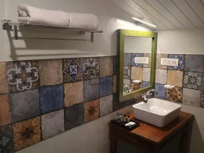 a bathroom with a sink and a mirror at Welbeck Vintage By Oxygen Resorts in Ooty