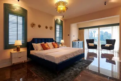 a bedroom with a large bed and a chandelier at Clouds Nest By Aanvis Inn in Ooty