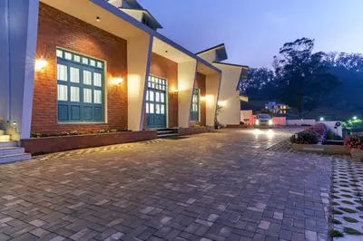 an empty courtyard of a building at night at Clouds Nest By Aanvis Inn in Ooty