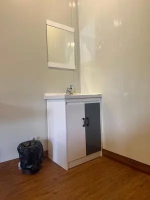a room with a white cabinet and a mirror on the wall at WHOOSH HOMES in Cochin