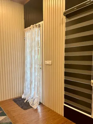 a door with a curtain in a room at WHOOSH HOMES in Cochin