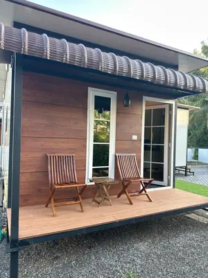 two chairs on a deck with a pergola at WHOOSH HOMES in Cochin