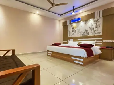 a bedroom with a bed and a tv on the wall at IvyArk Residency in Pinangode
