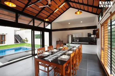 an open kitchen and dining room with a table and chairs at StayVista at Ava - The Country House with Breakfast & Miniature Golf in Mysore