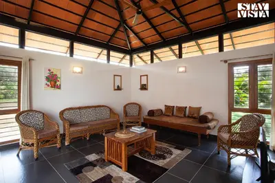 a living room with a couch and chairs and a table at StayVista at Ava - The Country House with Breakfast & Miniature Golf in Mysore