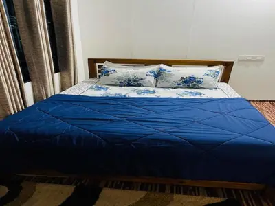 a bed with blue sheets and pillows in a room at KURUVA SHORELINE WAYANAD in Chekadi