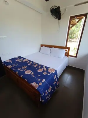 a bedroom with a bed in a room with a window at KURUVA SHORELINE WAYANAD in Chekadi
