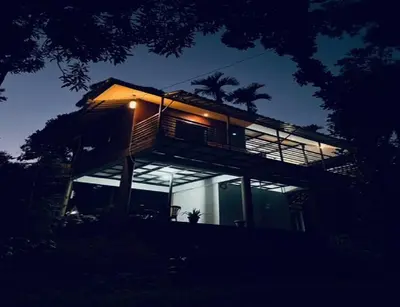 a house with lights on the side of it at night at KURUVA SHORELINE WAYANAD in Chekadi