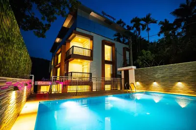 a house with a swimming pool in front of a house at Bluemist Resorts in Athirappilly