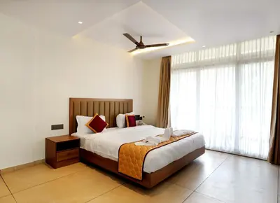 a bedroom with a bed and a large window at Bluemist Resorts in Athirappilly