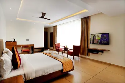 a hotel room with a bed and a desk at Bluemist Resorts in Athirappilly