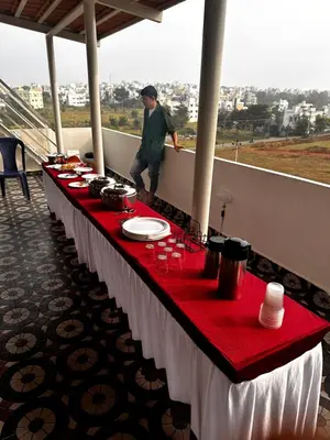 a red and white table with food on it at DEEYA Home Stay - A Luxury Family Guest House in Mysore