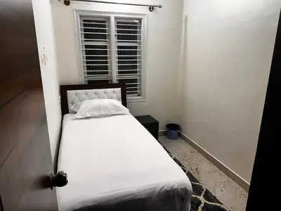a bed in a room with a window at DEEYA Home Stay - A Luxury Family Guest House in Mysore