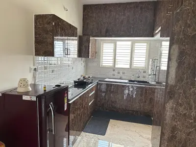 a kitchen with a sink and a refrigerator at DEEYA Home Stay - A Luxury Family Guest House in Mysore
