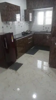 an empty kitchen with a refrigerator in a room at DEEYA Home Stay - A Luxury Family Guest House in Mysore