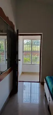 a room with a window and a bed and a door at SHI's Alaya 3BHk Villa in Coimbatore, near Railway station in Pīlamedu