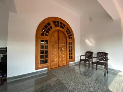 two chairs and a wooden door in a room at S VILLA in Wayanad