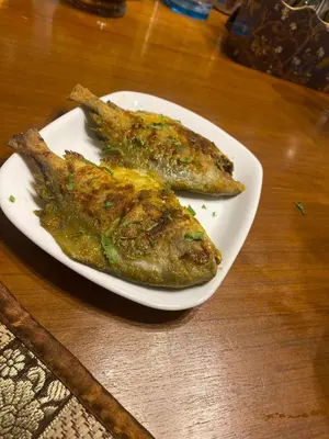 two pieces of fish on a white plate on a table at S VILLA in Wayanad