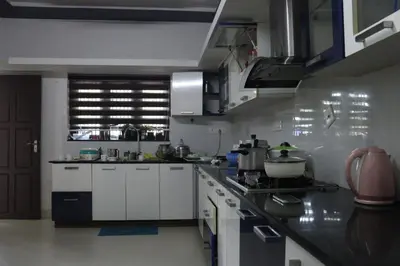 a kitchen with white cabinets and a counter top at S VILLA in Wayanad