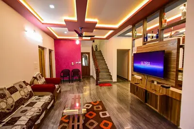 a living room with a couch and a flat screen tv at S VILLA in Wayanad