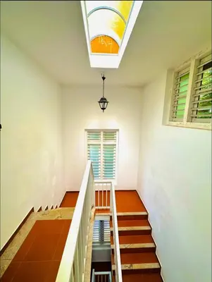 a staircase in a house with a skylight at THALIMALA BUNGALOW in Vythiri