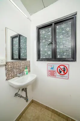 a bathroom with a sink and two windows at Shola Gardens , Kotagiri in Kotagiri