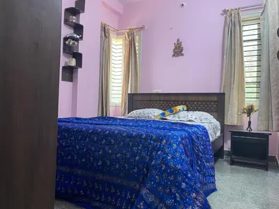 a bedroom with a bed with a blue comforter at Lovely Private Queen Bed Room in Shared 2 BHK Apartment in Mysore