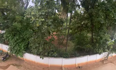 a fence with a bunch of trees and bushes at Lovely Private Queen Bed Room in Shared 2 BHK Apartment in Mysore