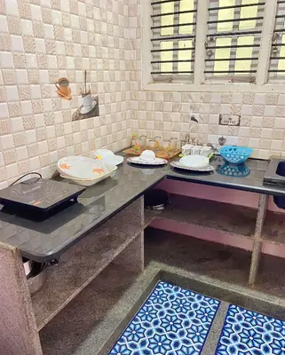 a table with plates on it in a kitchen at Lovely Private Queen Bed Room in Shared 2 BHK Apartment in Mysore