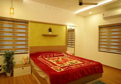 a bedroom with a bed with a red comforter at Luxury Homes - Cochin Airport - Nedumbassery in Angamali