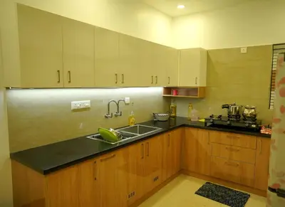 a kitchen with wooden cabinets and a sink at Luxury Homes - Cochin Airport - Nedumbassery in Angamali