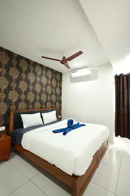 a bedroom with a bed with a blue ribbon on it at Wayanad Palace in Ambalavayal