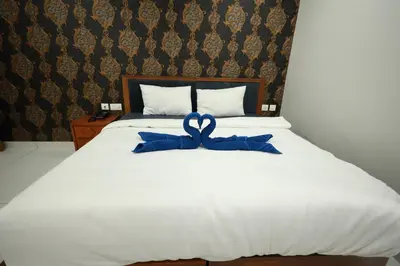a white bed with a blue ribbon on it at Wayanad Palace in Ambalavayal