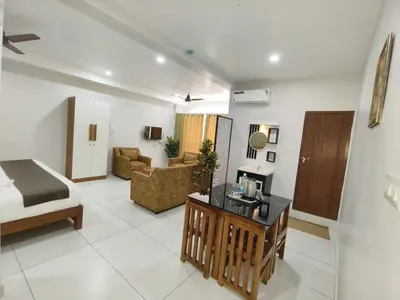 a hotel room with a bed and a living room at Wayanad Palace in Ambalavayal