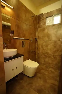 a bathroom with a toilet and a sink at Pabis luxurious stay in Vythiri