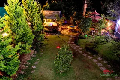 an aerial view of a garden with trees and a house at Sriniketana Homestay in Madikeri