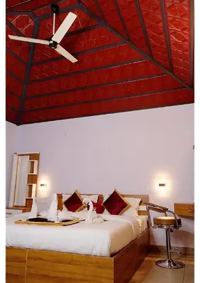 a bedroom with a bed with a ceiling fan at Sriniketana Homestay in Madikeri
