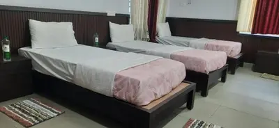 two beds in a hotel room with pink sheets at Sriniketana Homestay in Madikeri