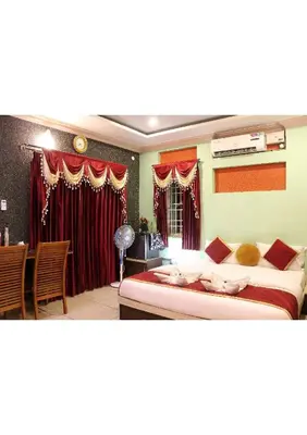 a bedroom with a large bed and a dining room at Sriniketana Homestay in Madikeri
