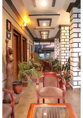 a lobby with chairs and plants in a building at Sriniketana Homestay in Madikeri