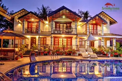 a house with a swimming pool in front of it at Sriniketana Homestay in Madikeri