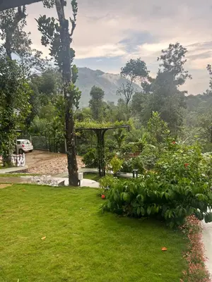 a garden with a pergola and green grass at SylVan Resort in Wayanad