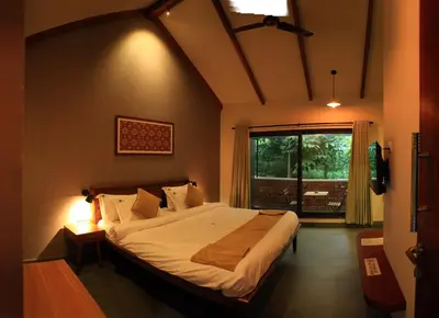 a bedroom with a large bed and a large window at SylVan Resort in Wayanad