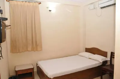 a small bedroom with a bed and a window at MYSORE MAHALAKSHMI ROOMS in Mysore