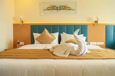 a large bed with a white swan decoration on it at Hotel Turmeric in Erode