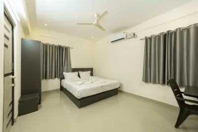 a bedroom with a bed and a desk in it at Fortune Inn in Erode