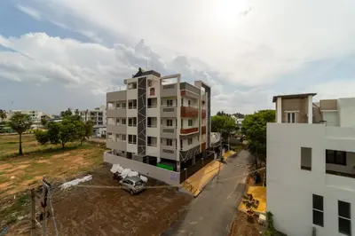 an apartment building with a car parked in front of it at Fortune Inn in Erode